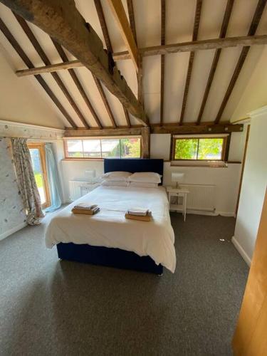 a bedroom with a large bed in a room at Oyster Barn sleeps six, North Norfolk in Roughton