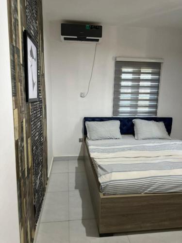 een slaapkamer met een bed en een tv aan de muur bij THE VILLA ABUJA in Abuja