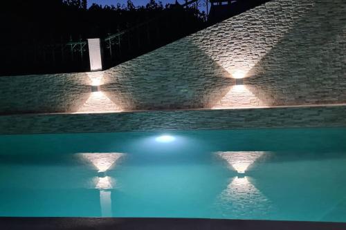 a swimming pool with lights on a brick wall at Paradise House Ground floor apartment in Villa with private pool and private garden in Abrantes