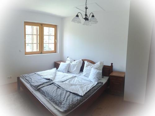 a bedroom with a bed with white sheets and pillows at Balaton Rustic Guesthouse in Badacsonytördemic