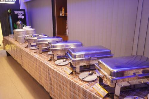 a buffet line with blue containers on a table at Grand Mostafa Hotel Ababil in Sylhet