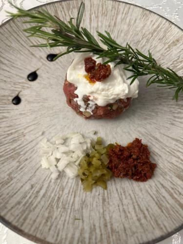 a white plate with a pastry on a table with a green garnishment at Hotel Kresowianka in Konin