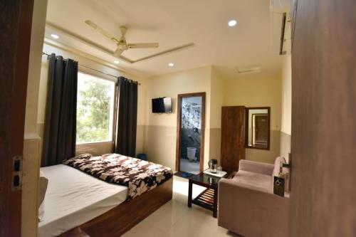 a bedroom with a bed and a chair and a window at Royal Inn Jammu in Jammu
