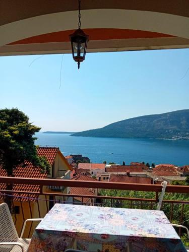 a table on a balcony with a view of the water at Guest House Cinderella in Herceg-Novi