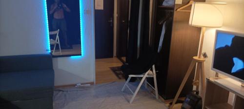 a room with a chair and a tv and a lamp at Studio appartement avec piscine, ski Porte du soleil Morgins, PS3 games, wash & bring sheets in Morgins