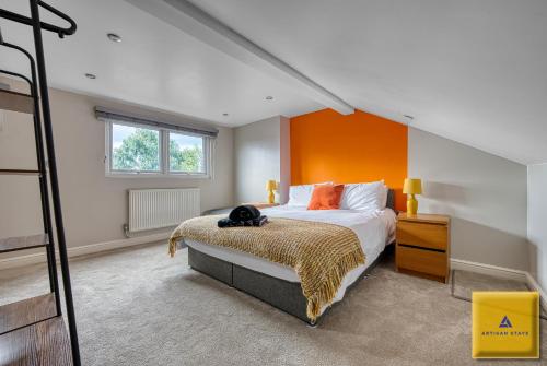 a bedroom with a bed with an orange wall at 4 Bedroom, 6 Beds, 3 Bathrooms, Near NEC & Birmingham Airport, Business, Contractor and Family Friendly, Free Wi-Fi, Free Parking in Coventry