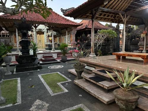 a pavilion with a wooden bench in a courtyard at Umah Desa in Banjarangkan