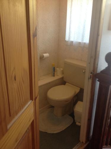 a small bathroom with a toilet and a window at Tanglin Guest House in Oban