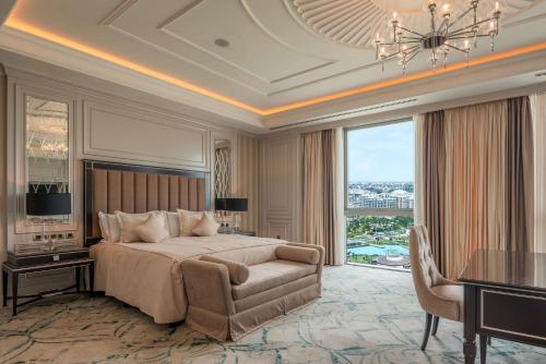 a bedroom with a bed and a table and a chair at Hilton Tashkent City in Tashkent