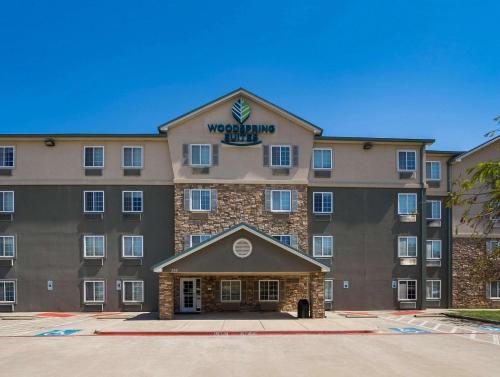 a large building with a sign on top of it at WoodSpring Suites Fort Worth Trophy Club in Trophy Club