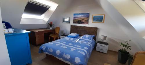 1 dormitorio con 1 cama con edredón azul en Le chant des oiseaux, en Montmartin-sur-Mer
