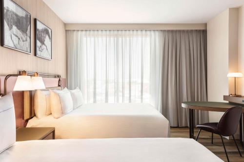 a hotel room with two beds and a desk at Doubletree By Hilton Abilene Downtown Convention Center in Abilene