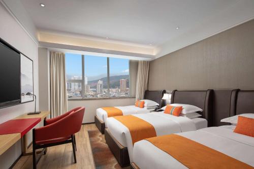 a hotel room with three beds and a large window at Hawthorn by Wyndham Dali Erhai Park in Dali