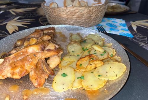 a plate of food with chicken and potatoes on a table at Lodge le jardin créole in Bras-Panon