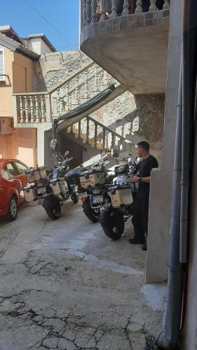 a man is standing next to a row of four assault weapons at Apartment Jasna in Mostar