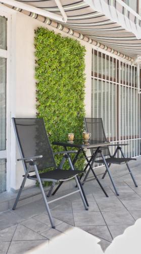 two chairs and a table on a patio at Cozy studio near the park with huge verandah. in Veliko Tŭrnovo