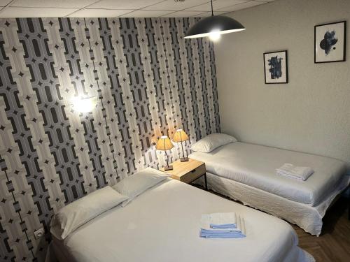 a bedroom with two beds and a window with curtains at Initial by balladins, Hôtel Restaurant Broisin in Aix-les-Bains