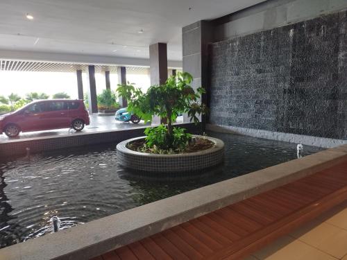 a lobby with a pond with a car in a parking lot at Rizky D'Bali Homestay @ Bali Residents Melaka in Melaka