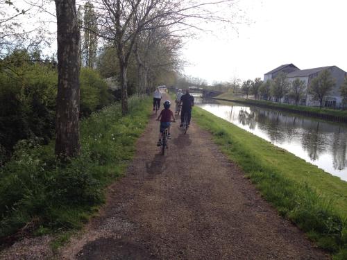 a group of people riding bikes down a path next to a river at Le Petit Robinson in Champvert