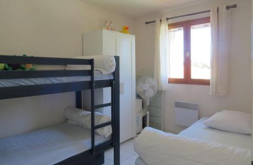 une chambre avec deux lits superposés et une fenêtre dans l'établissement Maisonnette 5 personnes avec belle terrasse, Parking 5JRD20, au Barcarès