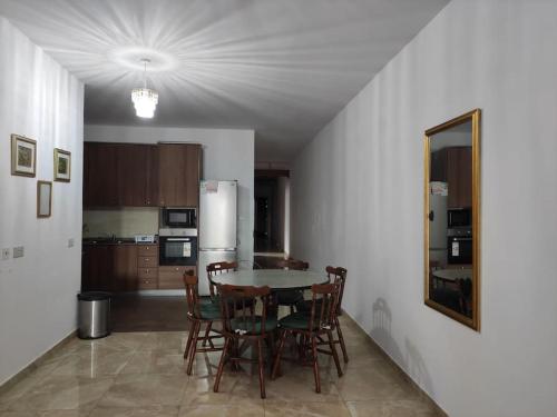 een keuken met een tafel en stoelen en een koelkast bij Serene apartment in Haz-Zebbug in Taʼ Srina