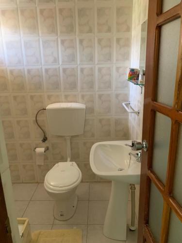 łazienka z toaletą i umywalką w obiekcie Residencial Pôr do Sol w mieście Porto Novo