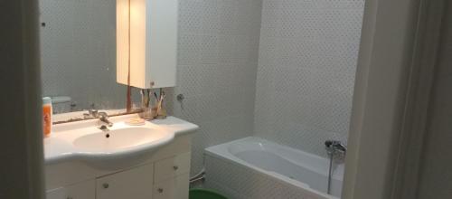 uma casa de banho com um lavatório e uma banheira em Well furnished appartment , Sahloul sousse em Sousse