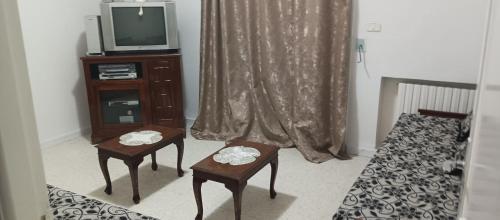 ein Wohnzimmer mit 2 Stühlen und einem TV in der Unterkunft Well furnished appartment , Sahloul sousse in Sousse