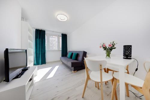a living room with a table and a tv at Crystal Apartment Katowice V in Katowice