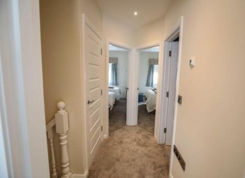 un pasillo con una habitación con 2 camas y una puerta en Seafront Sanctuary Ballycastle, en Ballycastle