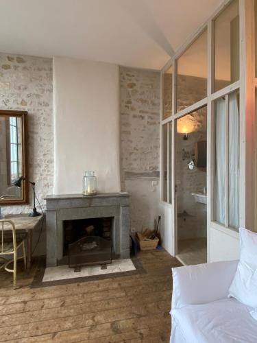 a living room with a fireplace and a couch at Hôtel Le Sénéchal in Ars-en-Ré