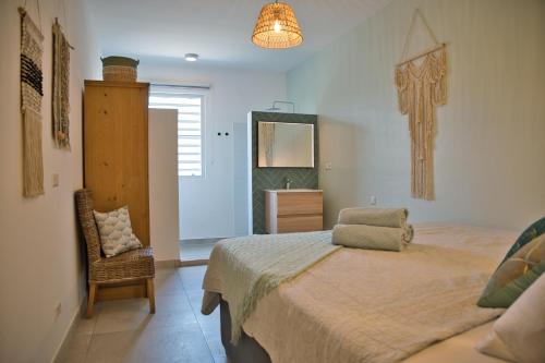 een slaapkamer met een bed, een stoel en een spiegel bij Caribbean Happyness in Willemstad