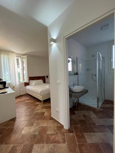 a bathroom with a shower and a sink and a bed at AFFITTACAMERE SAN MAMANTE in Santa Lucia delle Spianate