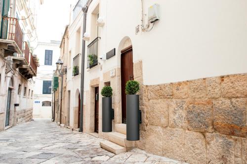 a street in an alley with buildings and potted plants at Bed and Breakfast Le Foglie in Altamura