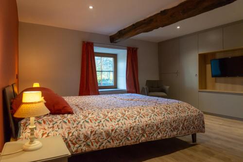 a bedroom with a bed with a lamp and a window at Le Temps d'une Fugue in Lierneux