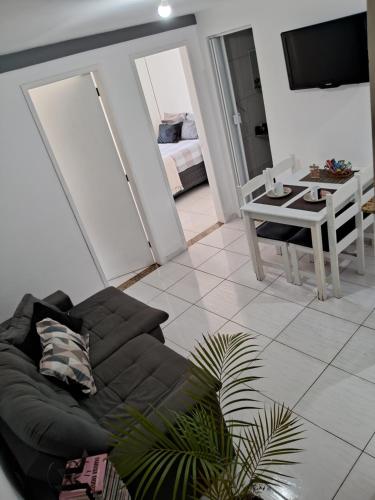 sala de estar con sofá negro y mesa en Solar do Pontal - Lindo Apartamento a 600m da praia, en Río de Janeiro