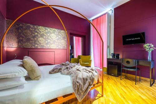 - une chambre avec un grand lit aux murs violets dans l'établissement Starguest Dante, à Naples