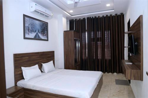 a bedroom with a bed and a television in it at Hotel Homeland Inn in Sirsa