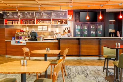 a restaurant with tables and chairs and a counter at Courtyard by Marriott Dallas Arlington South in Arlington