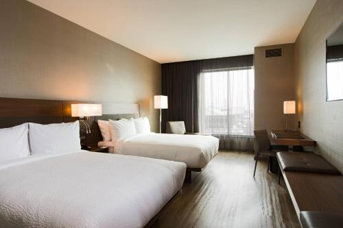 a hotel room with two beds and a window at AC Hotel Cincinnati at Liberty Center in West Chester