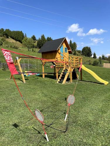a playground with a playset and a play house at Treeline Cabins in Cădăreşti