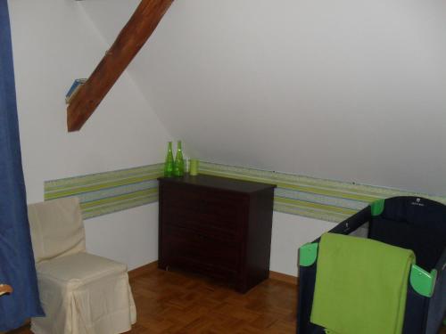 a room with a chair and a dresser in a room at Ferienhaus Duhra in Peitz