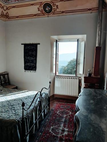 a bedroom with two beds and a large window at Nel borgo con vista castello in Poppi