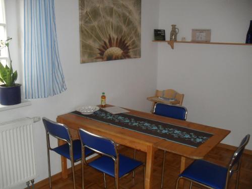 a dining room with a table and blue chairs at Ferienhaus Duhra in Peitz