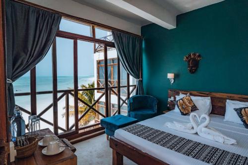a bedroom with a bed and a view of the ocean at Pili Pili Tropical Island in Jambiani