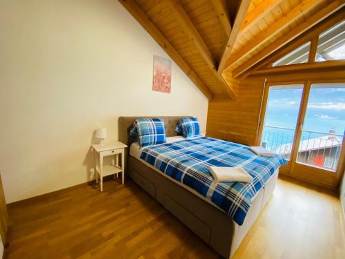 um quarto com uma cama num quarto com uma janela em LakeSide Villa - 18 em Niederried