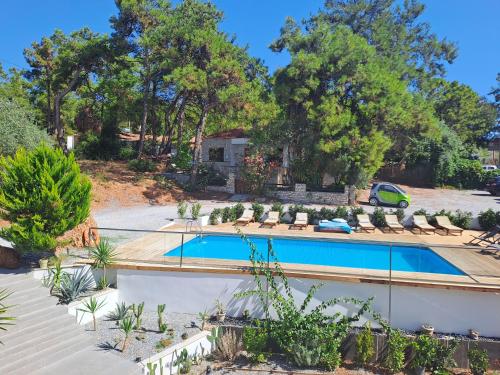 una piscina en un patio con sillas y árboles en Beach Hotel Kapahi en Pefkari