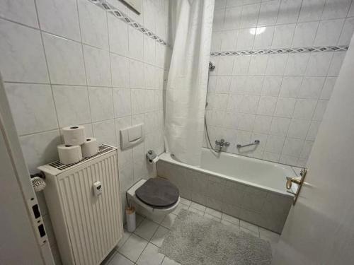 a white bathroom with a toilet and a bath tub at Lichtung Appartement - *WLAN**Netflix**Stadion-Nah* in Leipzig