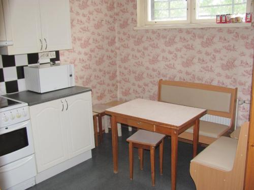 a kitchen with a table and a small table and a table and chairs at Economy Baltics Apartments - Liivamäe in Tallinn