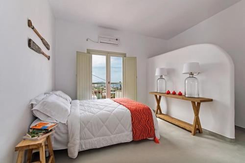 een witte slaapkamer met een bed en een raam bij Pyrgos terracevilla in Pirgos